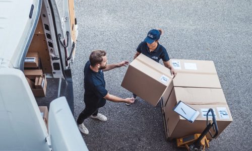 Delivery workers using a Hydraulic Hand Pallet Truck to load a delivery van.